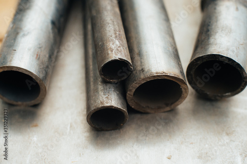 Stainless steel scrap metal, stainless steel pipes on the background of a stainless steel sheet. Close-up. Macro.