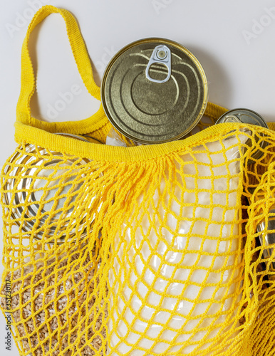 A set of long-term storage products in a string bag on a white background. Food donations