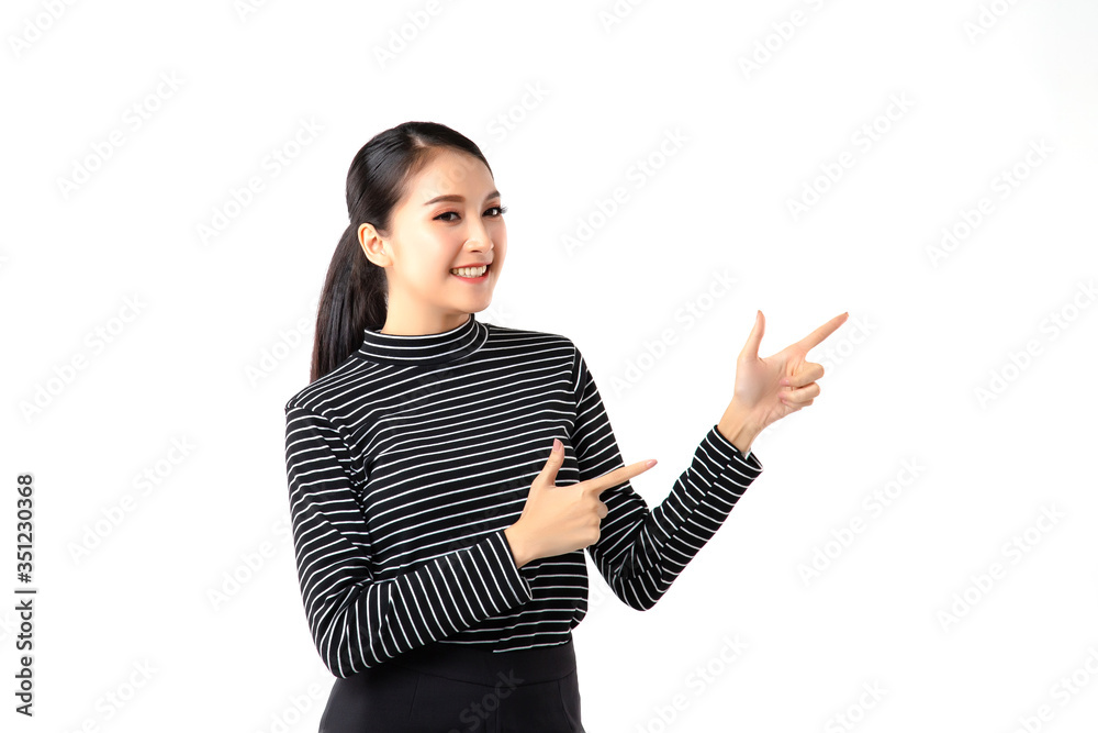 Happy Smiling Asian businesswoman wearing striped t-shirt pointing finger on copy space isolated on over gray background. She's looking at the camera with a Good smile and Nice teeth. studio shot Happy Smiling Asian businesswoman wearing striped t-shirt pointing finger on copy space isolated on over gray background. She's looking at the camera with a Good smile and Nice teeth. studio shot