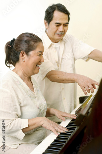 Senior man and woman playing piano