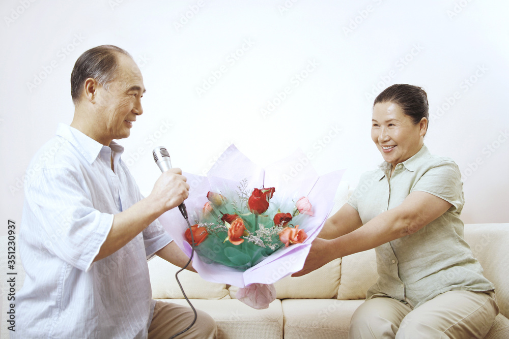 Senior man presenting senior woman with a bouquet of flowers Senior man presenting senior woman with a bouquet of flowers
