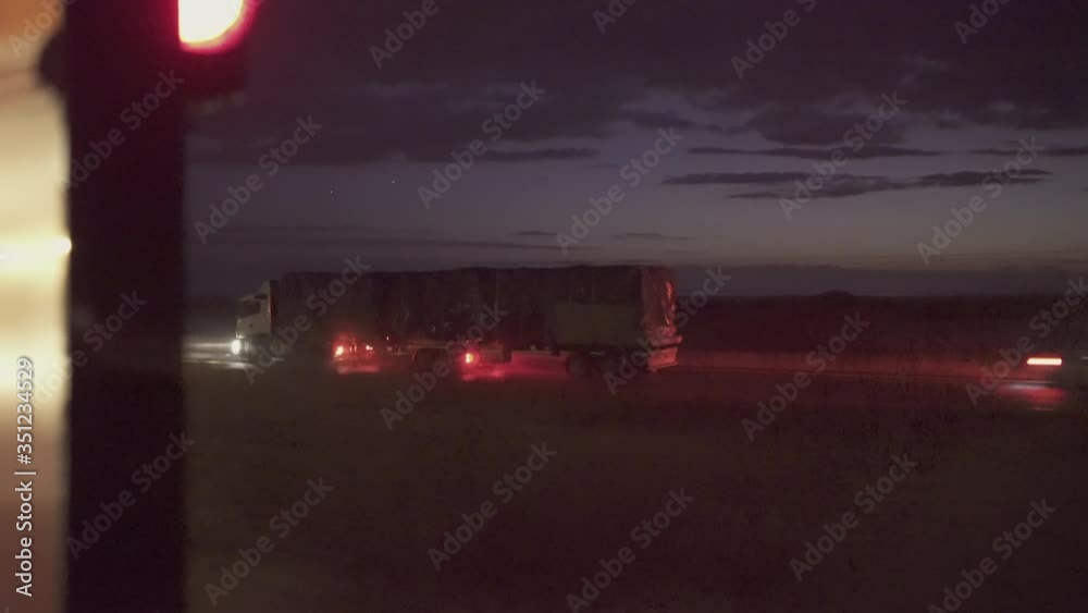 Panning shot of truck moving on road seen through train window at dusk - Swakopmund, Namibia Panning shot of truck moving on road seen through train window at dusk - Swakopmund, Namibia