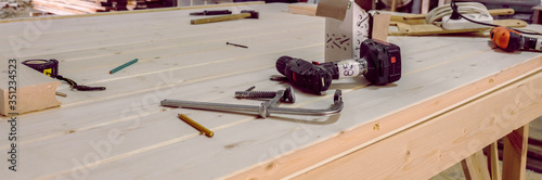 Carpentry tools lie on a wooden table. Joiner's shop. Concept of wood processing. Manufacture of wooden products. Mess on the carpenter's table.