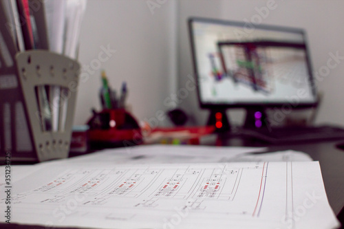 Engineering drawing on the background of a computer with engineering program. Selective focus. Engineering design of heating and water supply. Drawing of pipes and shut-off valves. Project design.