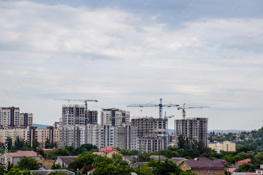 construction of multi-storey residential buildings. Tower cranes at a construction site.