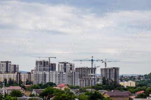 construction of multi-storey residential buildings. Tower cranes at a construction site.