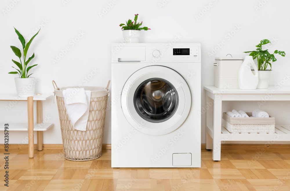 Rustic interior of home laundry room with modern washing machine - obrazy, fototapety, plakaty 