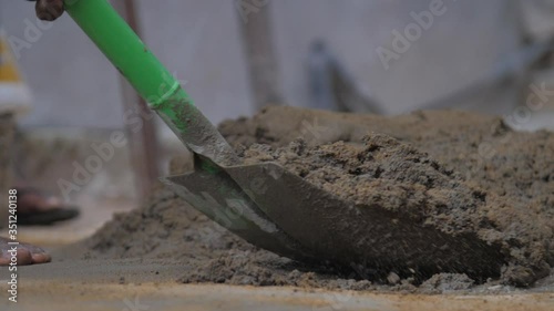 Wallpaper Mural professional construction worker mixes wet grey cement with green shovel slow motion close view. Concept slavery and poverty Torontodigital.ca