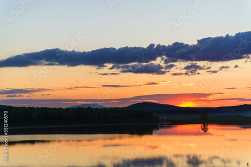 beautiful red sunset on the background of the lake and sky. reflection of the sunset in the water