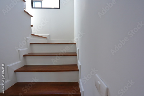 brown wooden stair and white wall in residential house Fototapeta