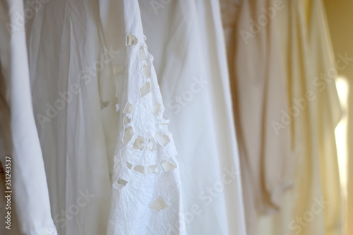 White vintage blouses on a clothing rack. Selective focus.
