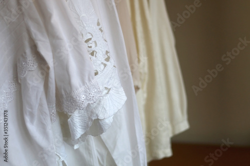 White vintage blouses on a clothing rack. Selective focus.