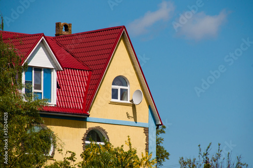 Large two-storey beautiful country house with red tiles, plastic windows and satellite dish