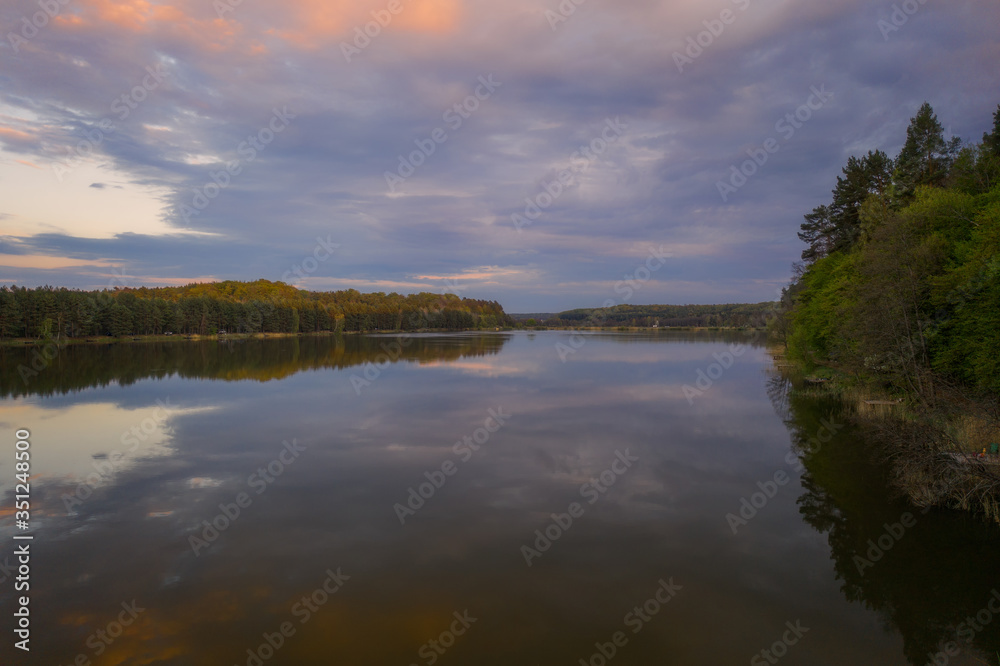 Evening sunset landscape with lake, spring and forest in Vereshchytsia, Lviv district. May 2020. Aerial drone view.
