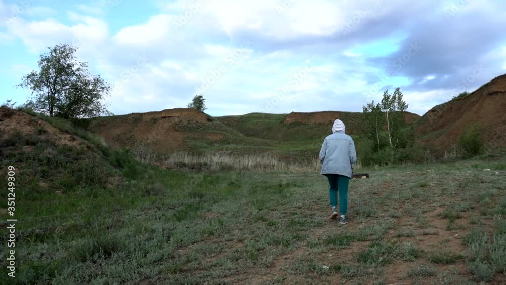 beautiful girl walks about a clay quarry in cool weather beautiful girl walks about a clay quarry in cool weather