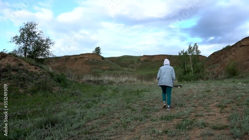 beautiful girl walks about a clay quarry in cool weather