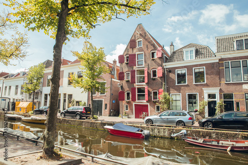 HAARLEM, NETHERLANDS, AUGUST 2019: Canal with historic houses in old Haarlem, the Netherlands, with lilac flowers. Europe tourism