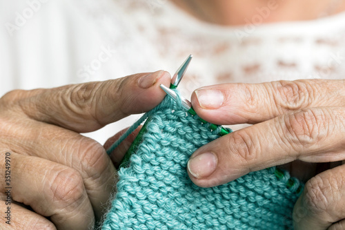 Close-up of hands knitting using circular needles.