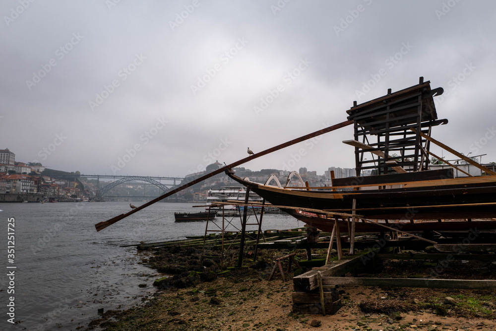 Seagulls perched on a boat mast above the Douro with the Dom-Luis bridge in the background in Porto.