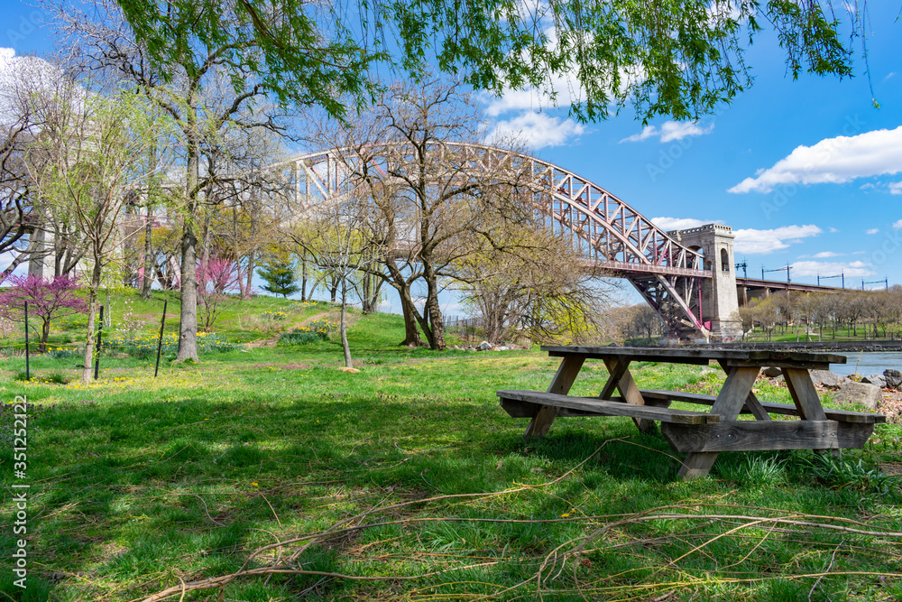 Empty Picnic Table during Spring along the East River on Randalls and Wards Islands of New York City with the Hell Gate Bridge in the background