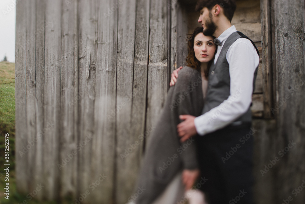 Romantic, young and happy caucasian couple in wedding clothes hugging on the background of beautiful mountains. Love, relationships, romance, happiness concept. Bride and groom traveling  together.