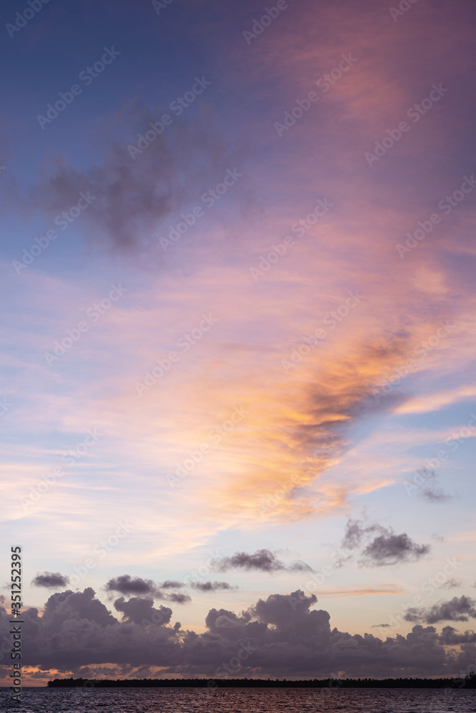 Fantastic view of a colorful sky at sunset over the sea. 
Low fluffy clouds. 