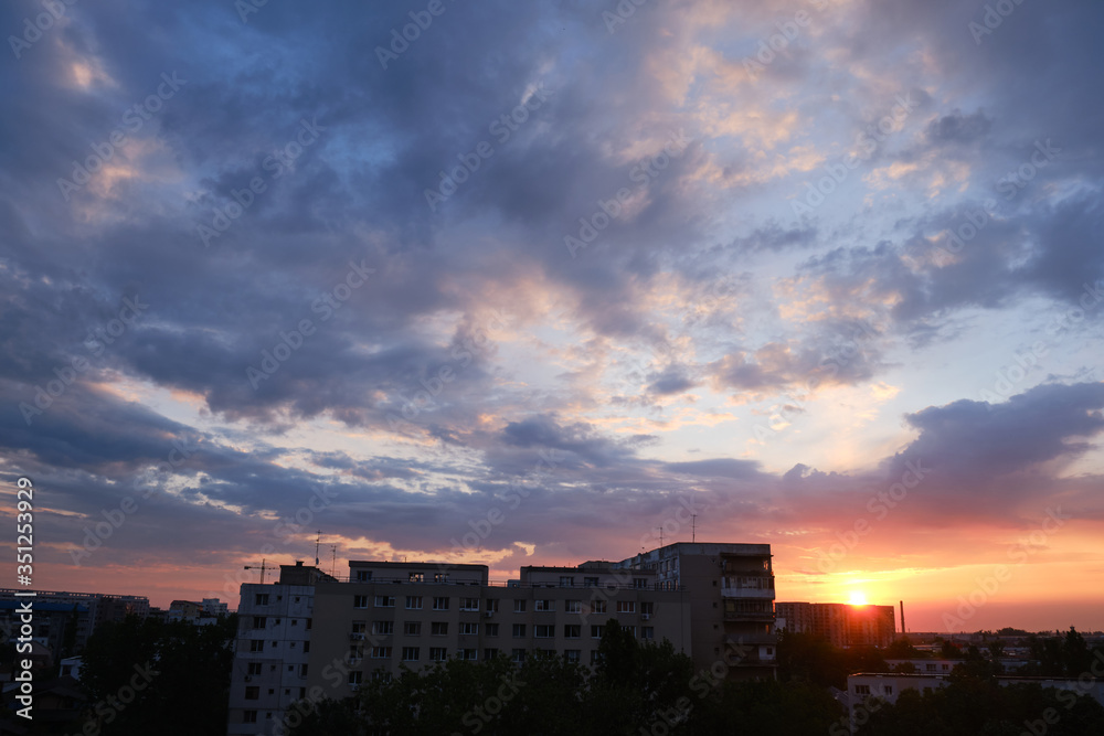 Urban sunrise with purple and orange clouds in the sky, after a storm, in Bucharest, Romania.