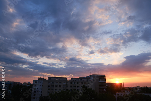 Obraz na płótnie Urban sunrise with purple and orange clouds in the sky, after a storm, in Bucharest, Romania. w salonie