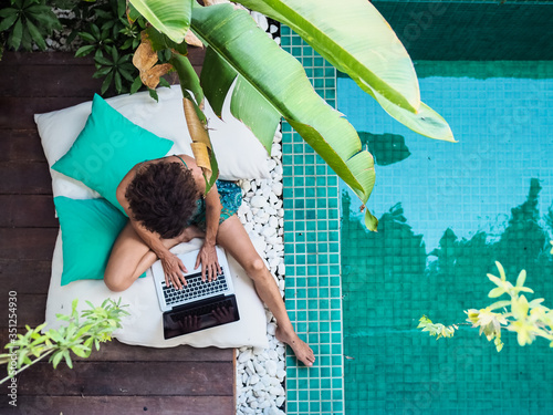 Fotografia, Obraz bird view of a remote online working digital nomad women with curly hair and lap