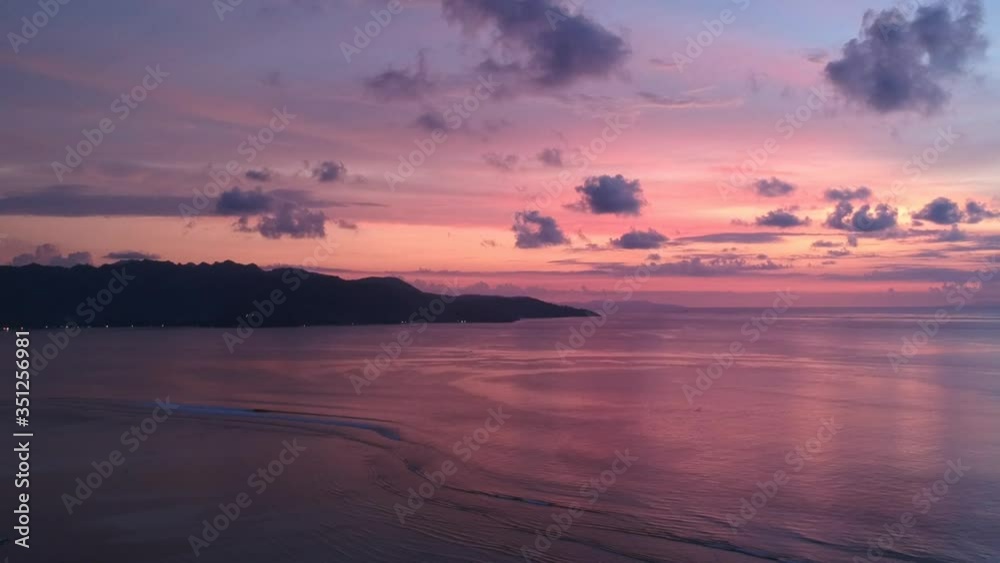 beautiful vanilla delicate sunset over the ocean with mountains on the horizon