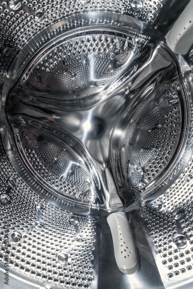 Drum of washing machine dry and clean close-up, inside view. Vertical photo