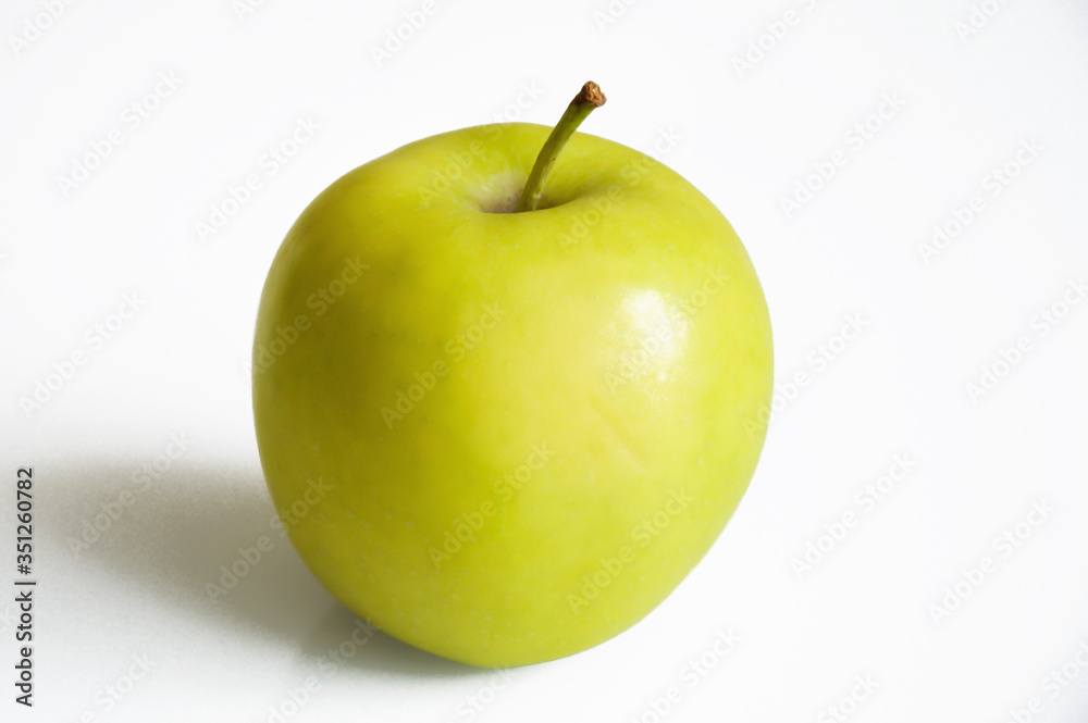 green ripe apple on a white background. juicy fruit.
