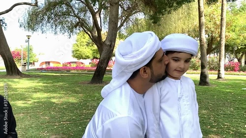 Emirati Arab father with Family Wearing Kandora. Arabic dad spending time with wife and son at a park. Happy Middle Eastern Family photo