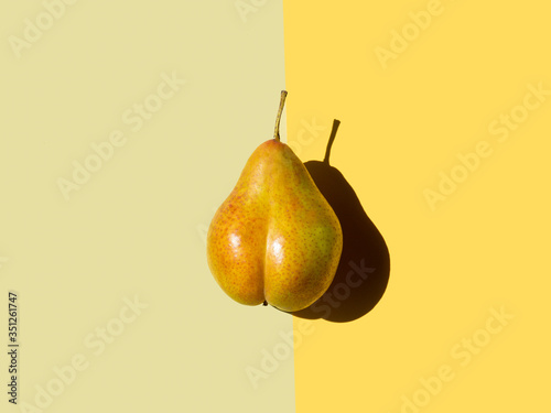 Fotografie, Obraz bottom shaped pear on yellow and olive background