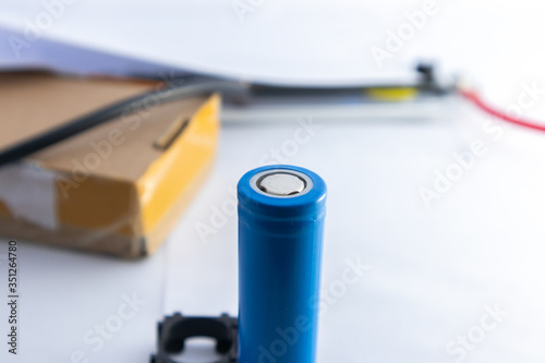 Blue lithium ion battery which placed vertically with blurred background.
