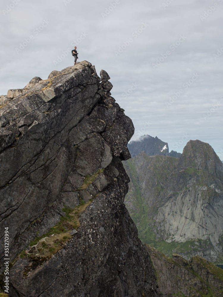 A Norwegian mountaineer stands on the peak of a mountain.