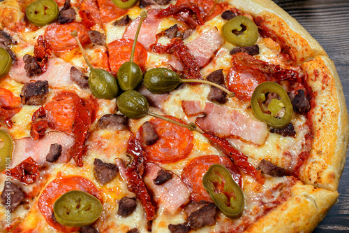 Pizza with jalapeno pepper, bacon and pepperoni, close-up