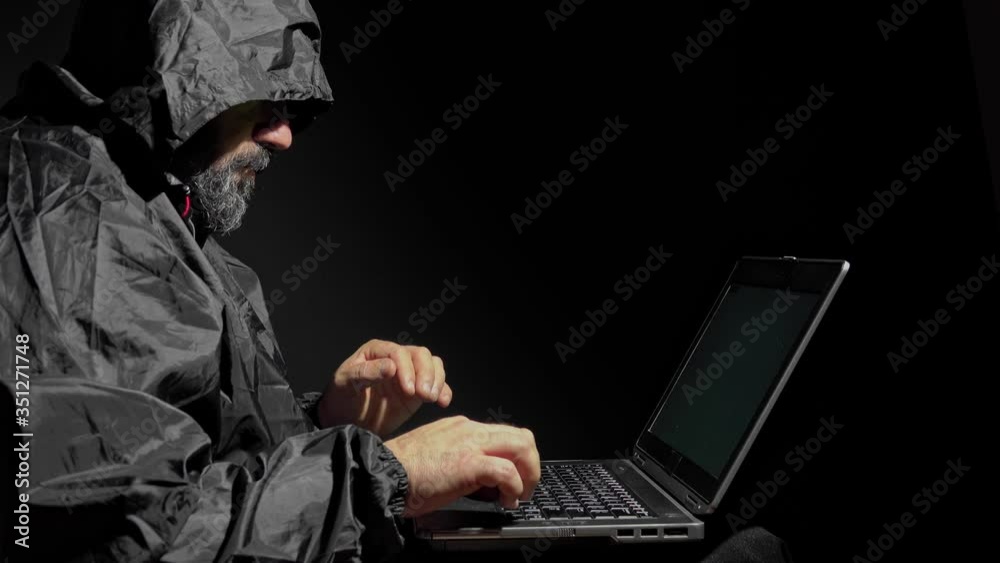 Computer hacker stealing data from a laptop. Concept for network security, identity theft and computer crime
Computer hacker stealing data from a laptop. Concept for network security, identity theft and computer crime