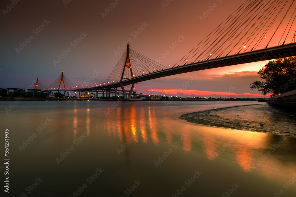 Obraz premium The blurred background of the twilight evening by the river, the natural color changes, the bridge over the river (Bhumibol Bridge) is one of the major transportation bridges in Bangkok, Thailand