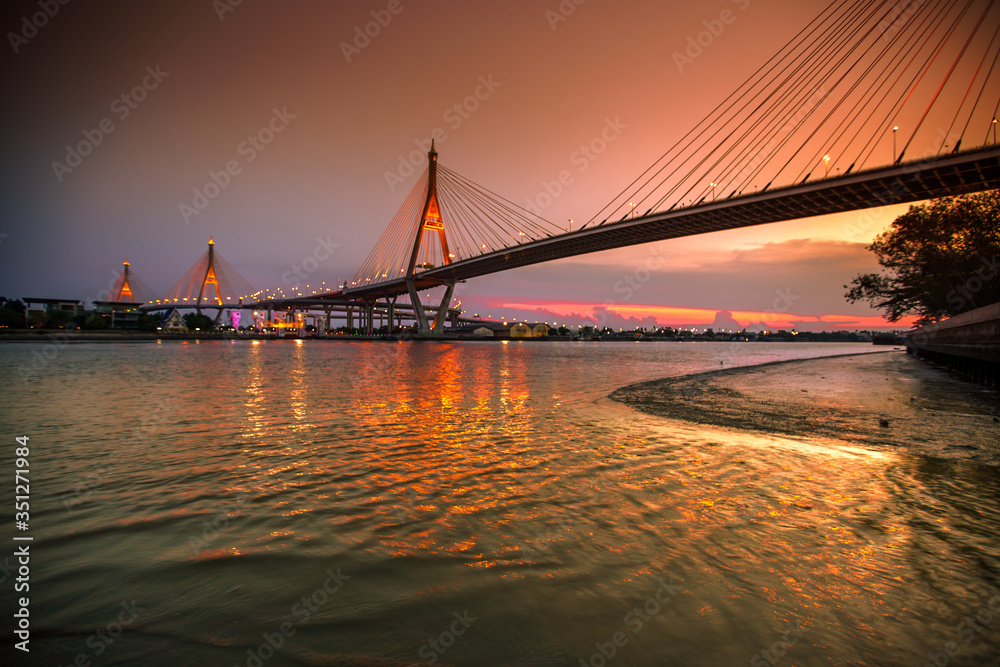 Obraz premium The blurred background of the twilight evening by the river, the natural color changes, the bridge over the river (Bhumibol Bridge) is one of the major transportation bridges in Bangkok, Thailand