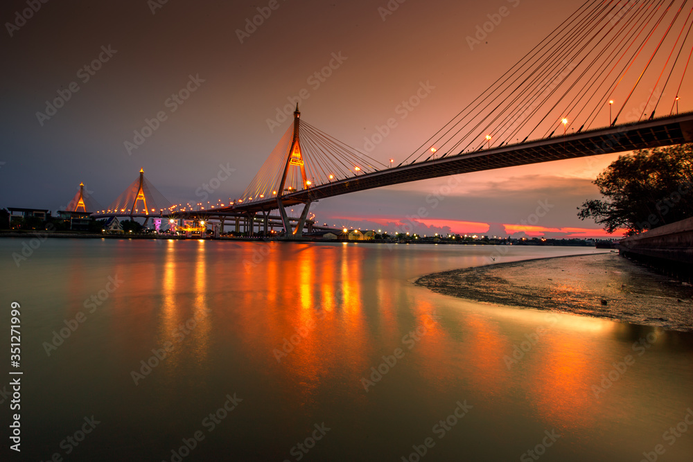 Obraz premium The blurred background of the twilight evening by the river, the natural color changes, the bridge over the river (Bhumibol Bridge) is one of the major transportation bridges in Bangkok, Thailand