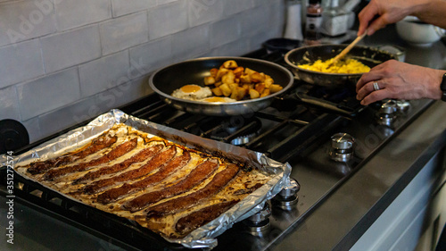 Preparing Bacon, hash browns, eggs for breakfast