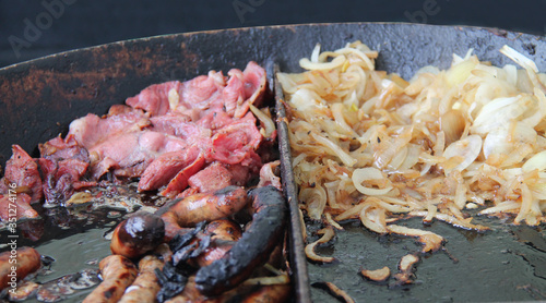 Photography Bacon Sausages and Onions Cooking in a Large Pan.