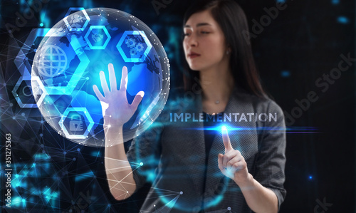 Business, Technology, Internet and network concept. Young businessman working on a virtual screen of the future and sees the inscription: Implementation