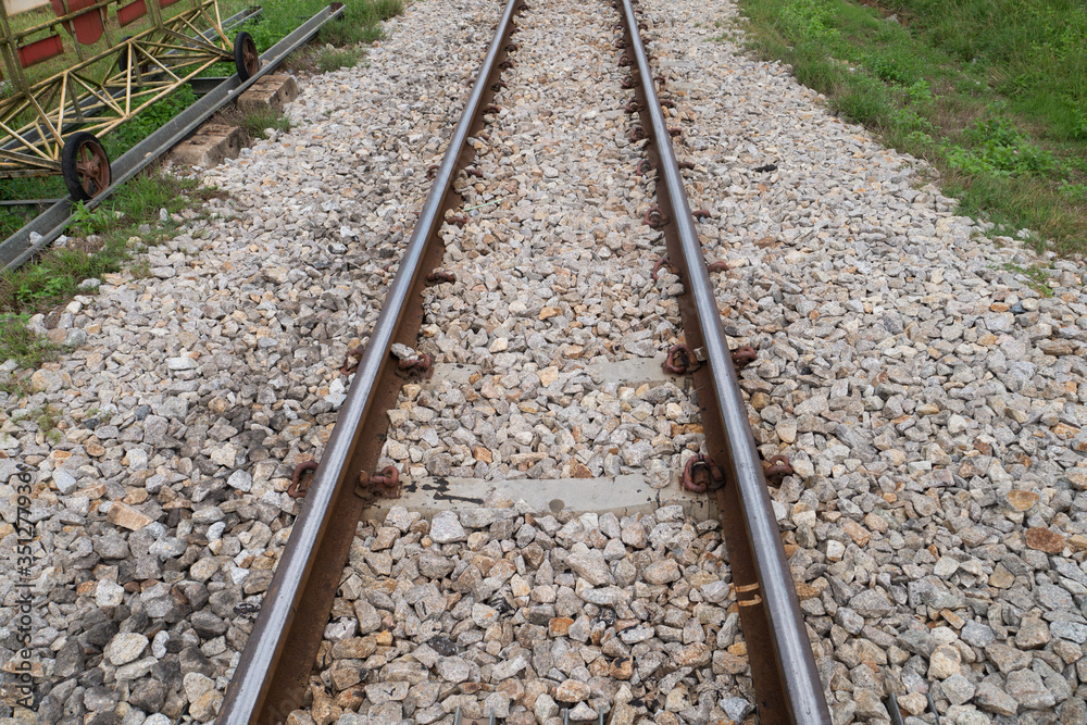 Metal railway and stone rock background for logistic freight transportation or direction concept Metal railway and stone rock background for logistic freight transportation or direction concept