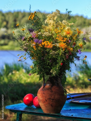 Bouquet of delicate field's flowers on the water background photo