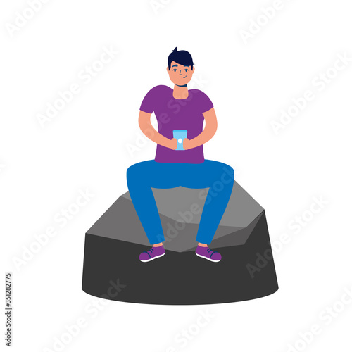 young man using smartphone seated in rock
