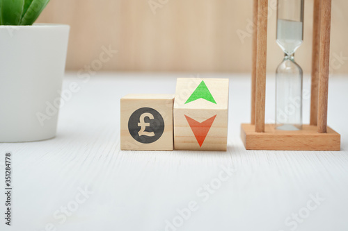 Wooden blocks with GBP pound sterling sign and up and down arrows. photo