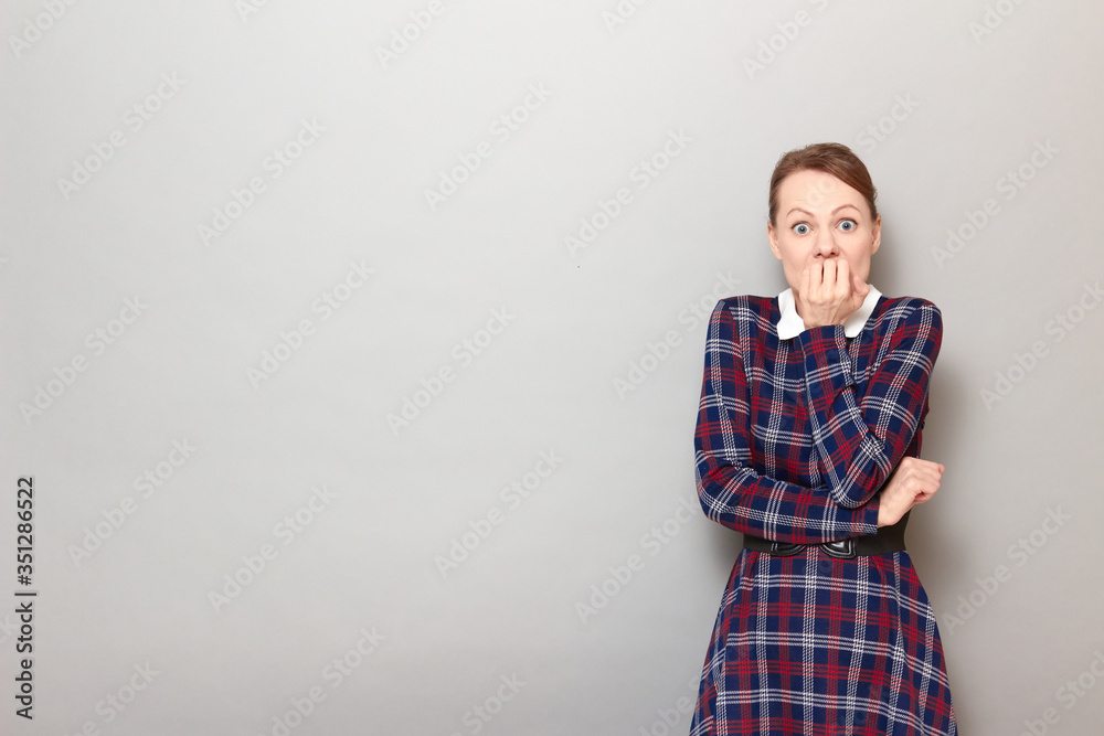 Portrait of shocked frightened girl biting her nails in panic Portrait of shocked frightened girl biting her nails in panic