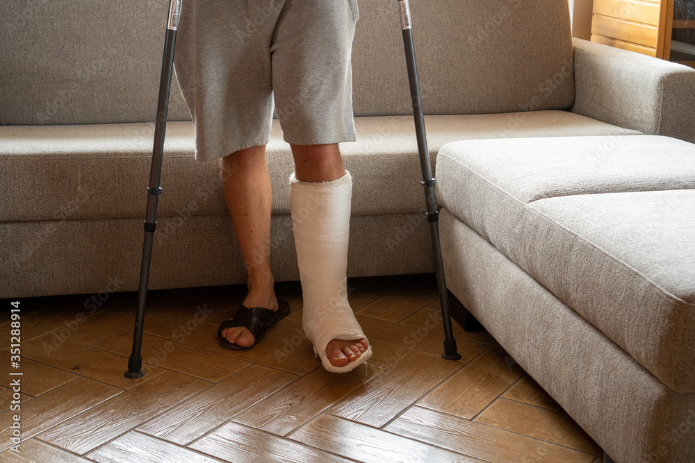 Young man recovering after accident at home with crutches Young man recovering after accident at home with crutches